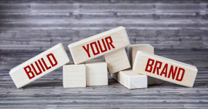 "A graphic showing colorful building blocks arranged to form the words 'Build your Brand.' The blocks symbolize the process of building and strengthening a brand's identity and visibility."